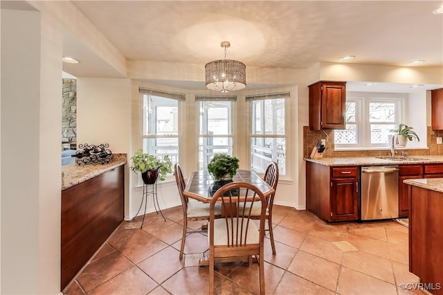 dining area with light tile patterned flooring, a notable chandelier, and baseboards