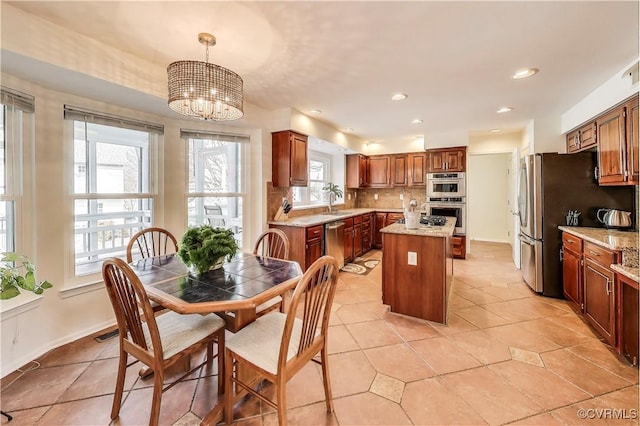 dining area featuring a notable chandelier, light tile patterned floors, baseboards, and recessed lighting