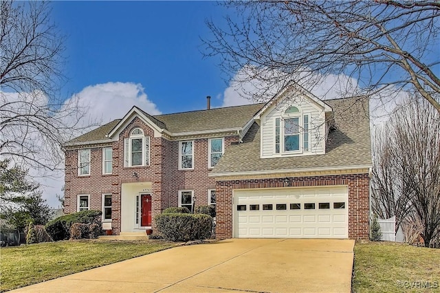 colonial house with a shingled roof, brick siding, fence, concrete driveway, and a front lawn