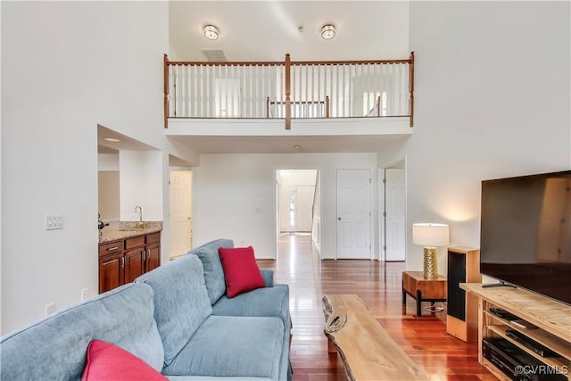 living area featuring a towering ceiling and wood finished floors