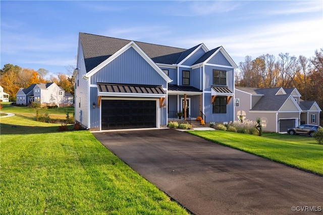 modern inspired farmhouse featuring a front yard, a standing seam roof, driveway, and metal roof