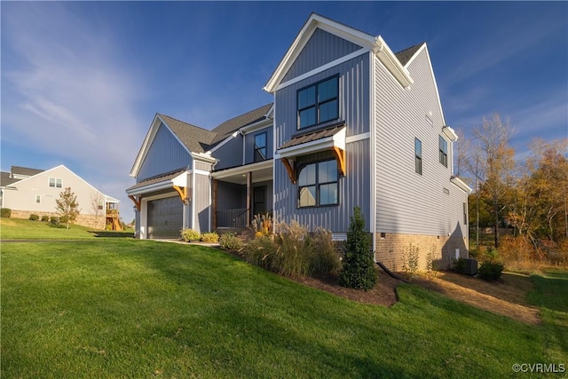 view of front of home with board and batten siding, a front yard, central AC, and an attached garage