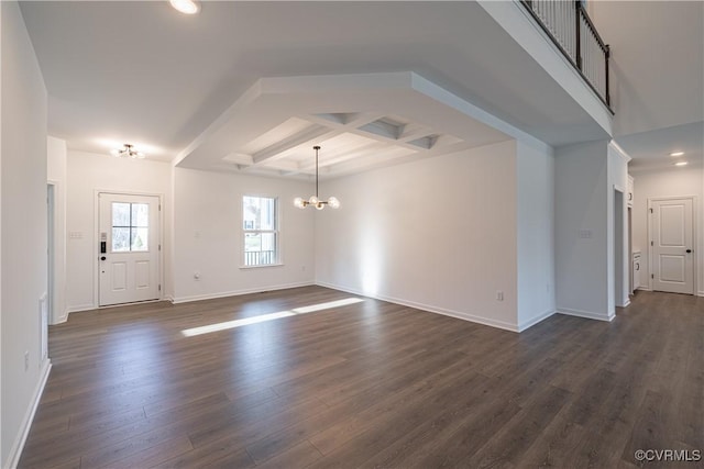 foyer entrance with dark wood-style flooring, coffered ceiling, baseboards, and an inviting chandelier