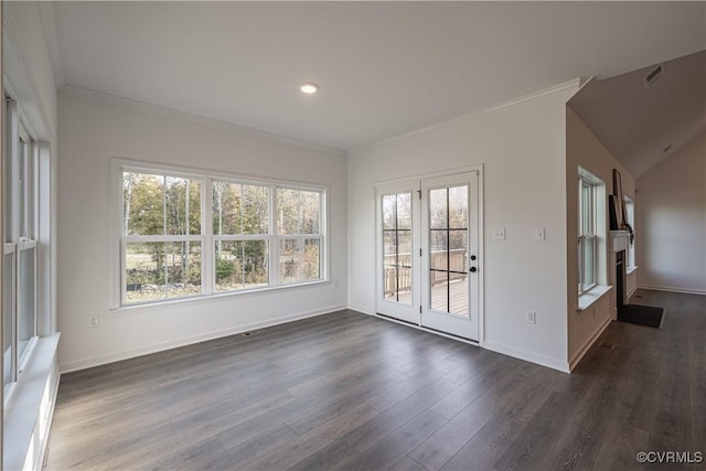 spare room with dark wood-style floors, ornamental molding, baseboards, and a healthy amount of sunlight