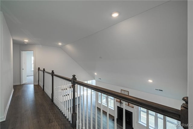 corridor with lofted ceiling, recessed lighting, wood finished floors, visible vents, and baseboards