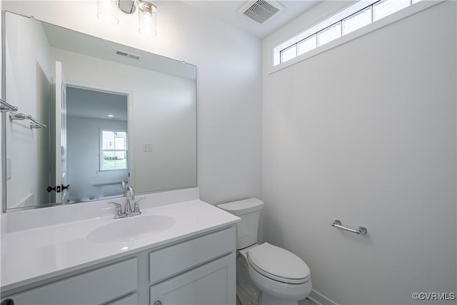 half bath with visible vents, plenty of natural light, and toilet