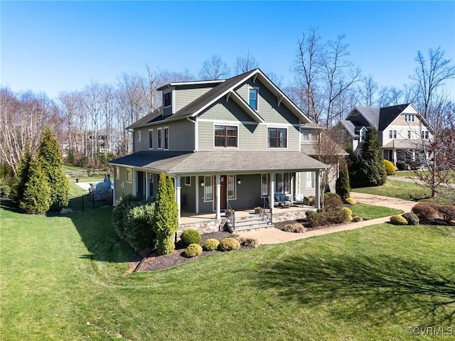 view of front of home featuring a front lawn, covered porch, and a shingled roof