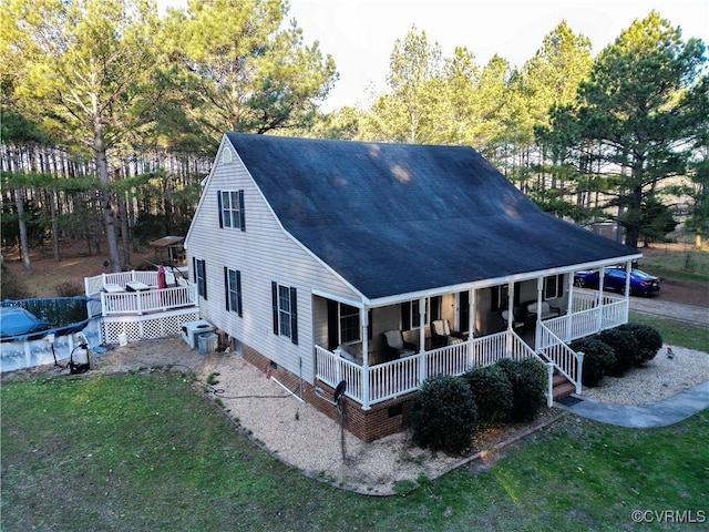 rear view of house with crawl space, a yard, a porch, and a shingled roof