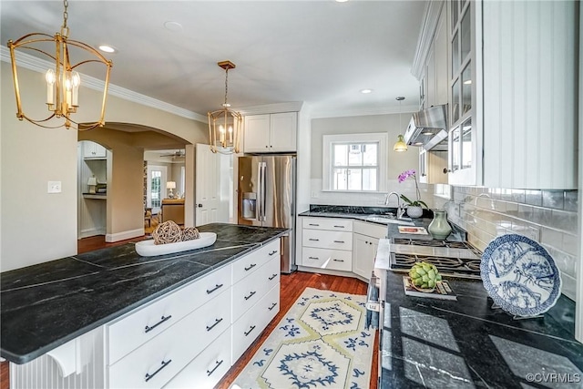 kitchen featuring stainless steel fridge with ice dispenser, dark wood finished floors, under cabinet range hood, ornamental molding, and arched walkways