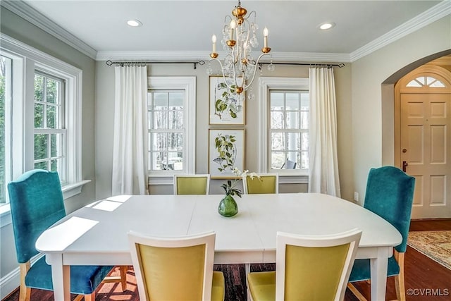 dining space featuring arched walkways, recessed lighting, wood finished floors, and ornamental molding