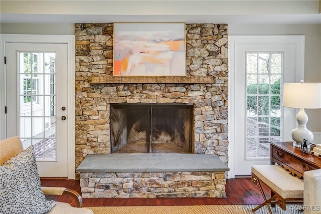 interior details featuring a stone fireplace and wood finished floors