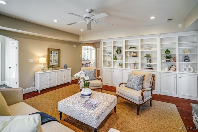 living room with recessed lighting, visible vents, arched walkways, and dark wood-type flooring