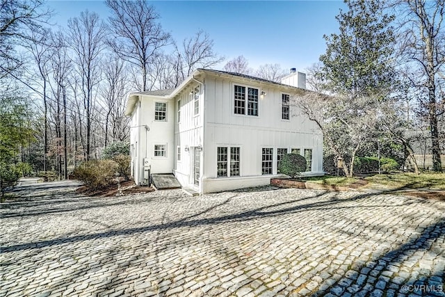 exterior space featuring board and batten siding and a chimney