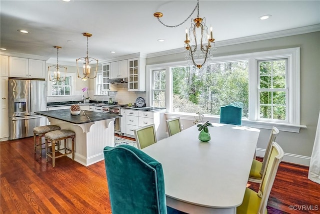 dining space featuring a healthy amount of sunlight, a chandelier, and dark wood-style flooring