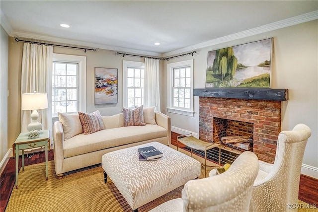 living area with a brick fireplace, crown molding, baseboards, and wood finished floors