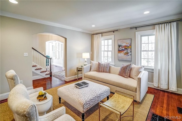 living room with a healthy amount of sunlight, wood finished floors, and crown molding