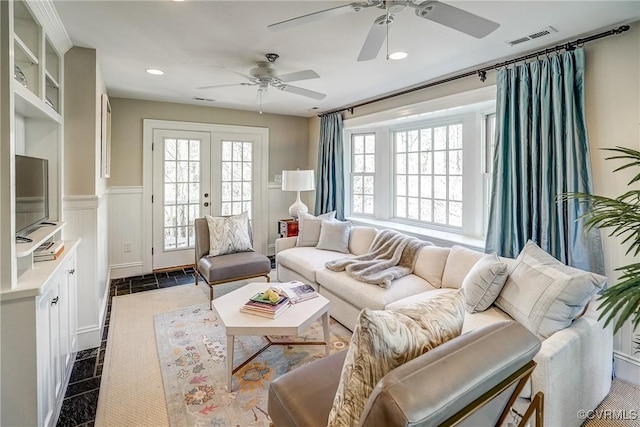 living room with visible vents, recessed lighting, french doors, wainscoting, and a decorative wall