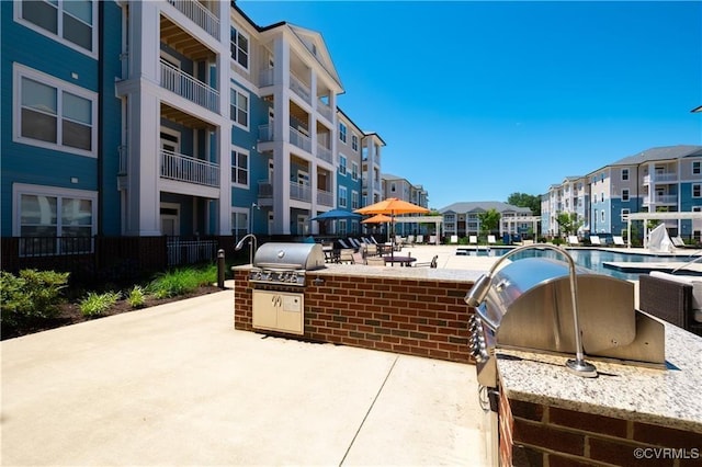 surrounding community with exterior kitchen, a residential view, and a patio area