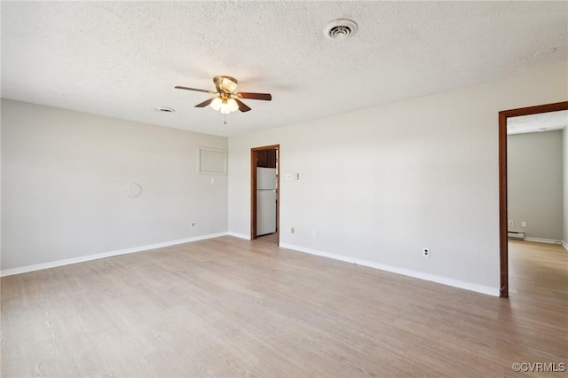 empty room featuring ceiling fan, light wood finished floors, visible vents, and baseboards