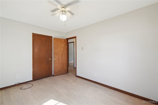 unfurnished bedroom with a closet, light wood-type flooring, a ceiling fan, and baseboards