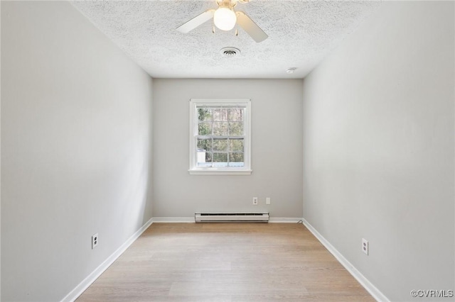 unfurnished room featuring visible vents, baseboard heating, ceiling fan, a textured ceiling, and light wood-type flooring