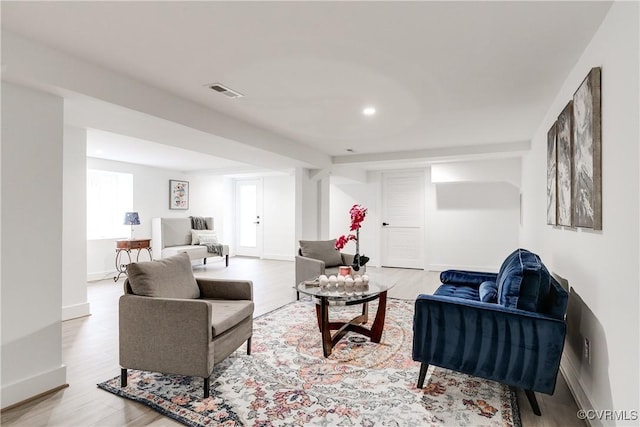 living room featuring recessed lighting, wood finished floors, visible vents, and baseboards