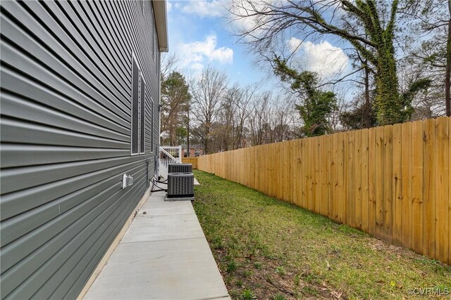 view of yard featuring fence and central AC