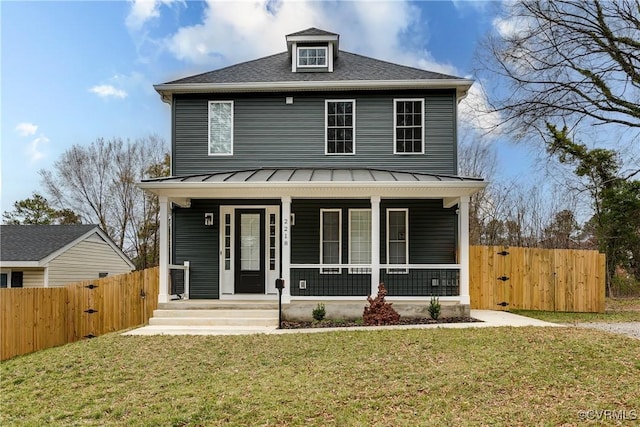 traditional style home with a porch, metal roof, a standing seam roof, fence, and a front lawn