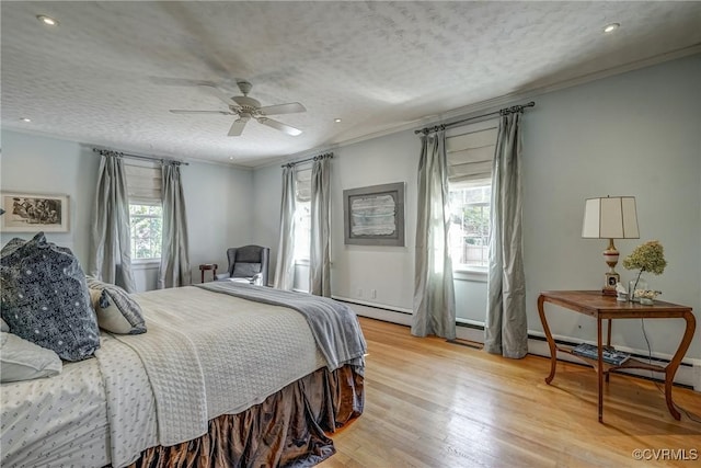 bedroom featuring light wood-type flooring, a ceiling fan, ornamental molding, and a textured ceiling