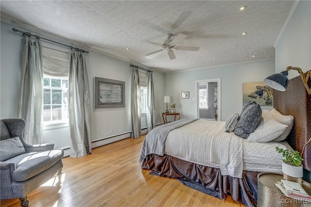 bedroom featuring light wood finished floors, a baseboard radiator, ceiling fan, ornamental molding, and a textured ceiling