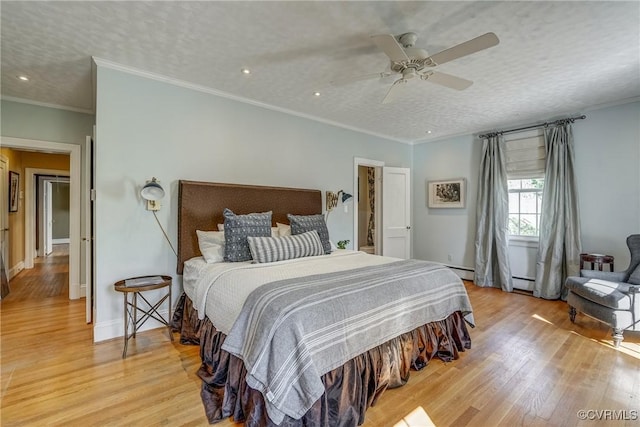 bedroom featuring light wood-style flooring, crown molding, baseboards, and a textured ceiling