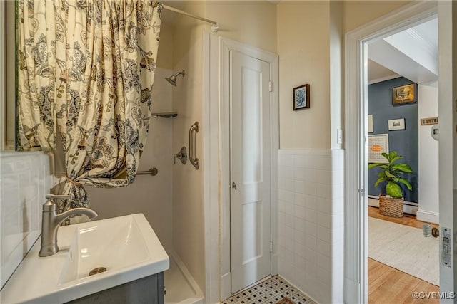 full bath featuring wood finished floors, a shower with shower curtain, a sink, and crown molding