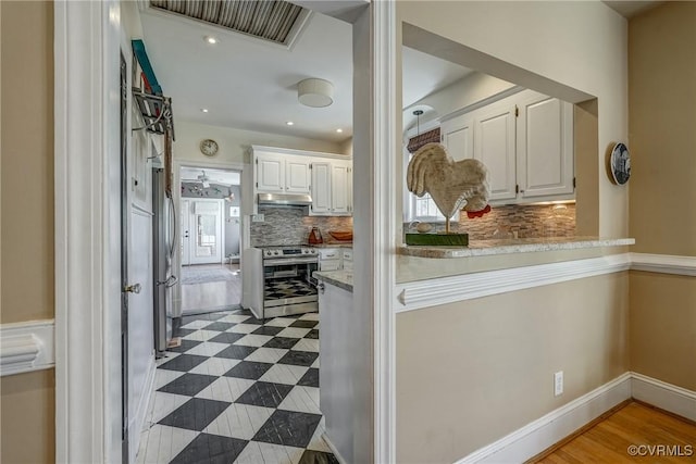 kitchen with visible vents, electric range, backsplash, white cabinets, and under cabinet range hood