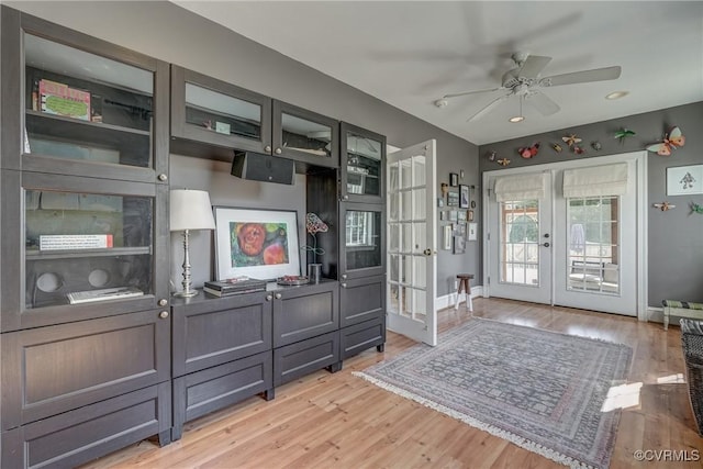 interior space with ceiling fan, french doors, light wood-type flooring, and baseboards