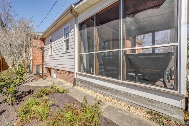 view of property exterior with crawl space and a sunroom