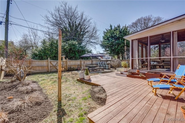 wooden deck with a sunroom and a fenced backyard