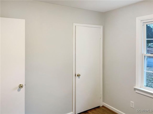 605 Conley Rd, Richmond, VA 23227 - unfurnished bedroom featuring multiple windows, baseboards, and dark wood finished floors