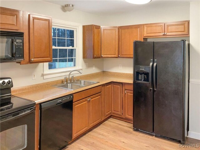 605 Conley Rd, Richmond, VA 23227 - kitchen with a sink, light wood-style floors, light countertops, black appliances, and brown cabinetry