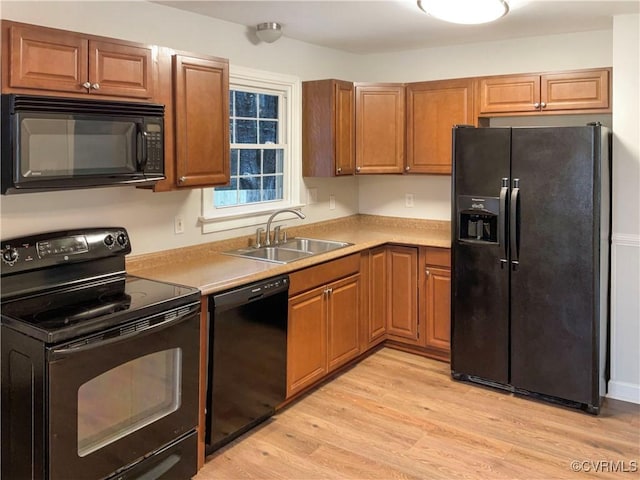 605 Conley Rd, Richmond, VA 23227 - kitchen featuring light wood-style flooring, a sink, light countertops, brown cabinets, and black appliances