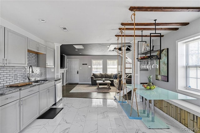 kitchen with visible vents, dishwasher, a sink, marble finish floor, and backsplash
