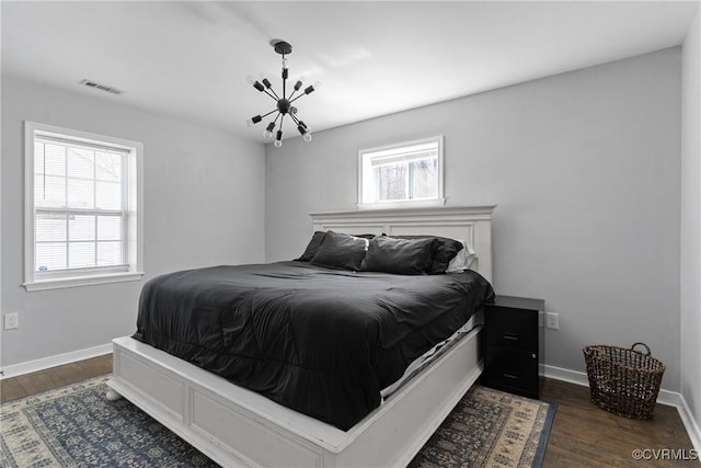 bedroom with dark wood-style floors, visible vents, and baseboards