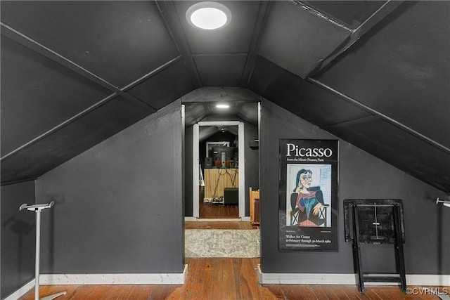 additional living space featuring vaulted ceiling and wood finished floors