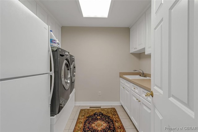 clothes washing area featuring light tile patterned floors, separate washer and dryer, a sink, visible vents, and cabinet space