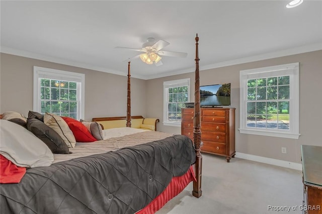 carpeted bedroom featuring ornamental molding, a ceiling fan, and baseboards