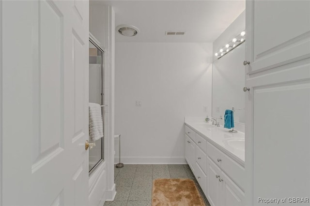 bathroom with double vanity, a sink, visible vents, and baseboards