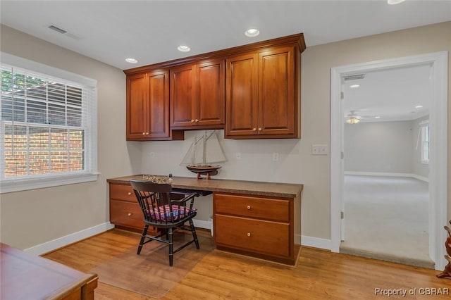 office area featuring baseboards, built in study area, visible vents, and light wood finished floors