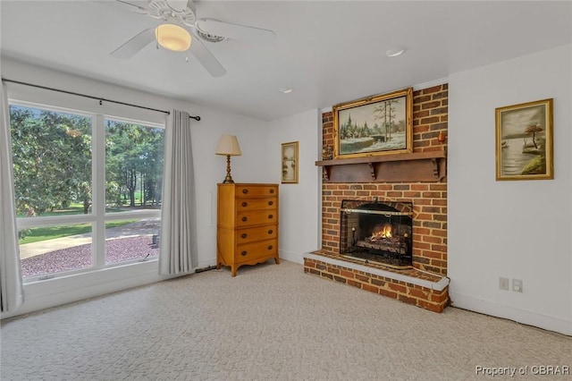 unfurnished living room featuring carpet, a fireplace, a ceiling fan, and baseboards