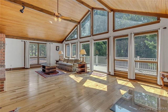 sunroom / solarium featuring vaulted ceiling with beams, wood ceiling, and a ceiling fan