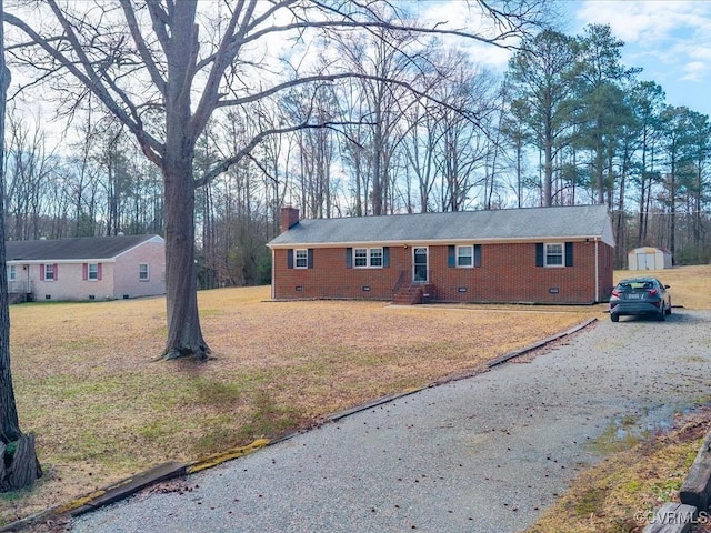 ranch-style house with brick siding, crawl space, a chimney, and a front yard