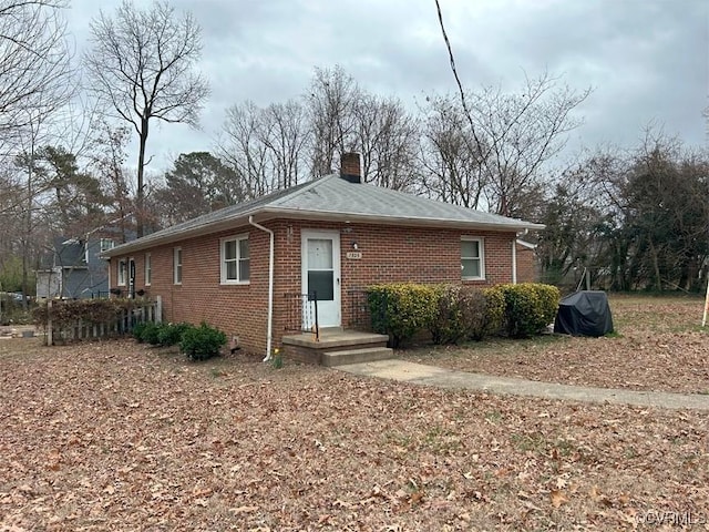 view of front of home with brick siding and a chimney